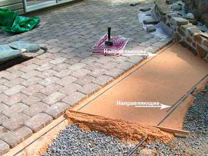 Установка направляющих в процессе укладки тротуарной плитки.